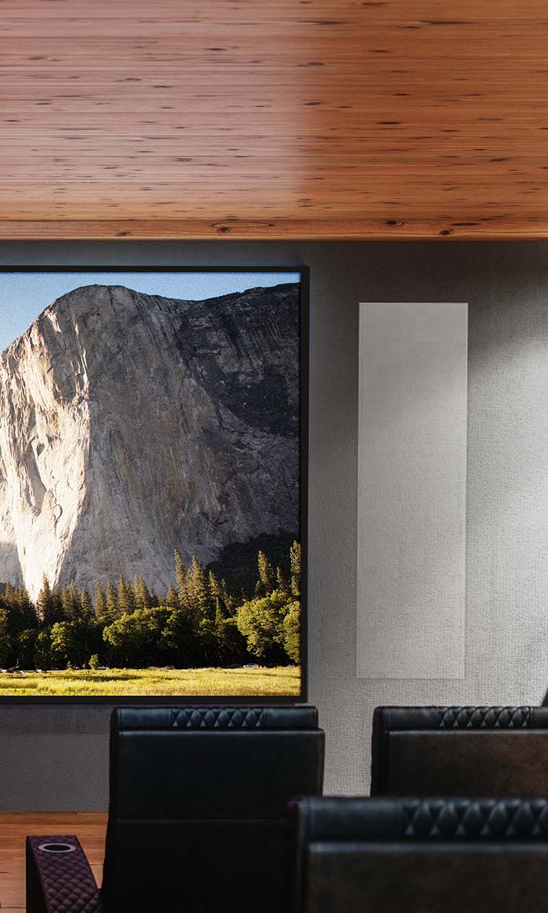 Tall rectangular acoustic wall panel mounted next to a large display screen
