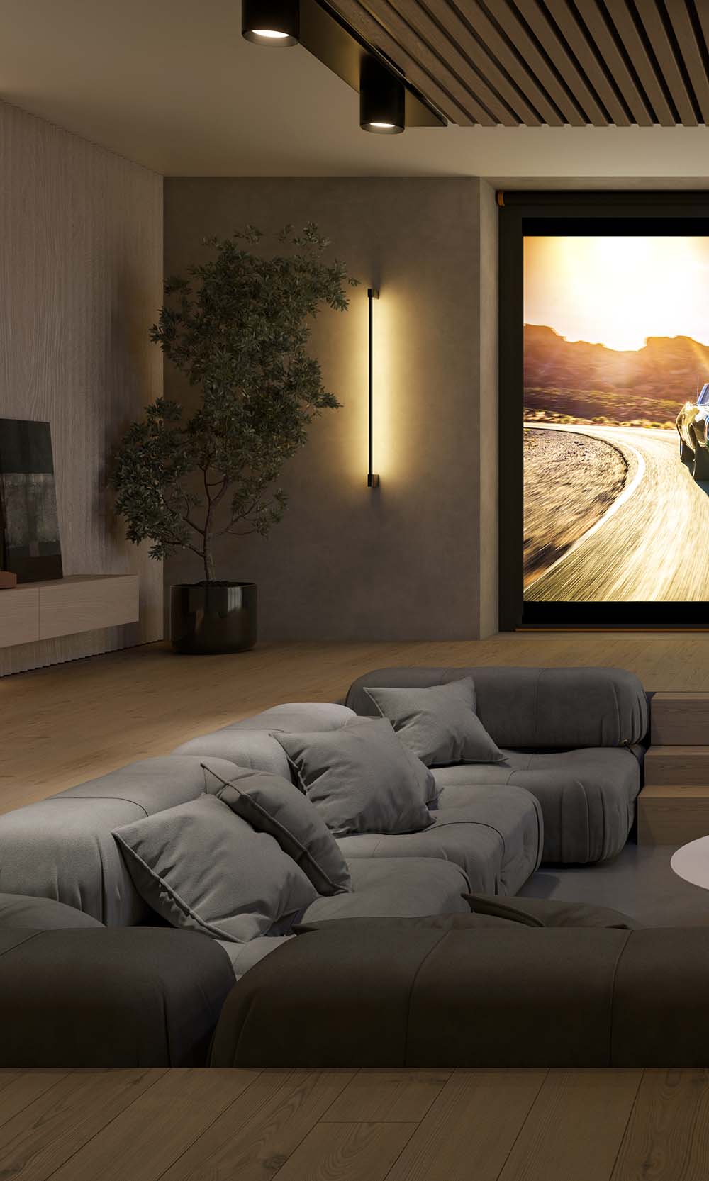 Modern media room with a low-profile grey sectional couch, ambient lighting, and a green plant