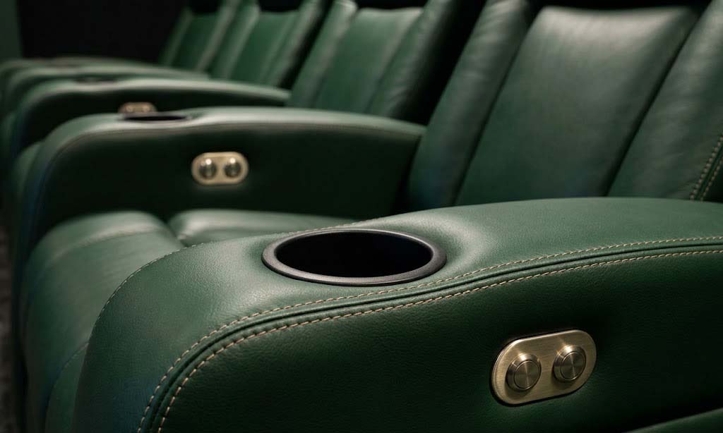 Close-up of green leather home theater reclining seats with integrated metal controls