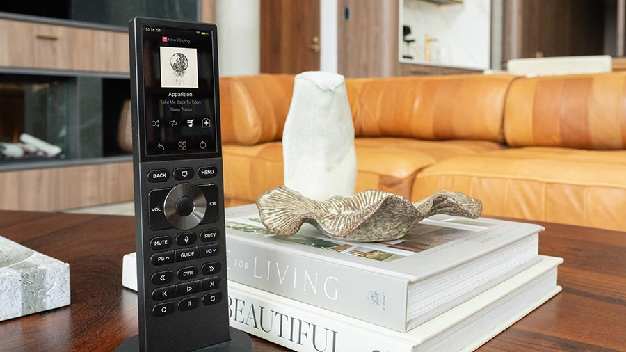 Sleek black smart remote controller standing on a coffee table book