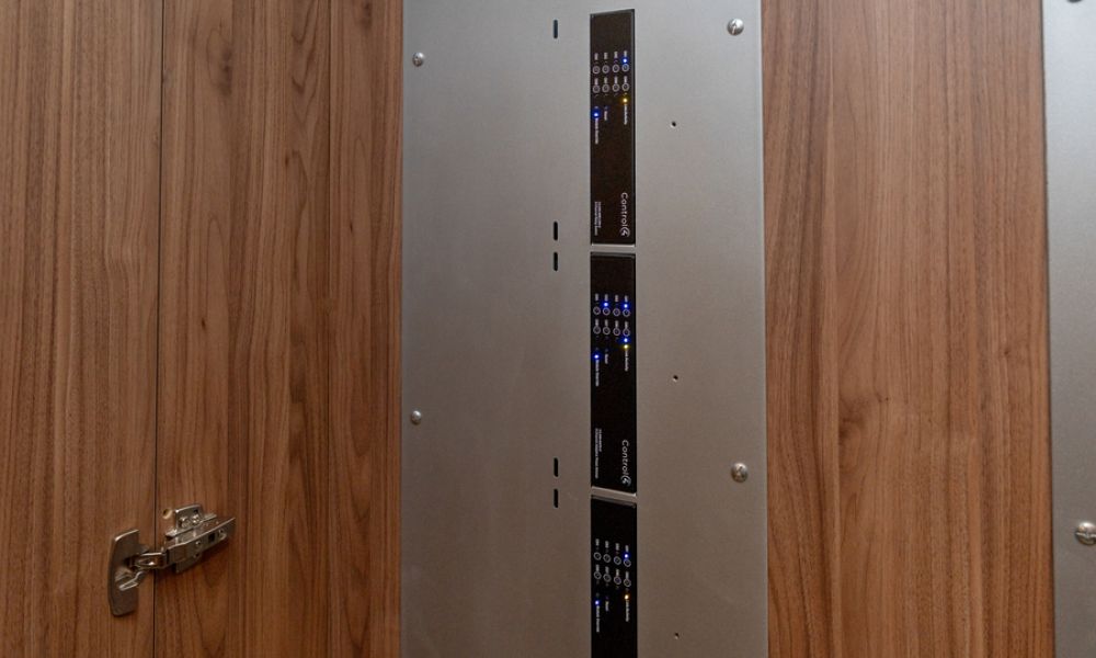 Control4 equipment rack mounted in a wood-paneled closet with labeled AV components