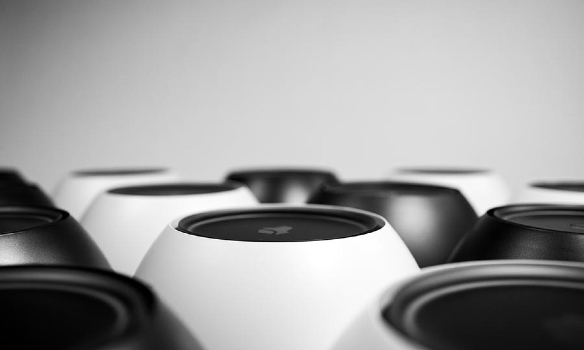 Array of modern circular smart home voice assistant devices in black and white